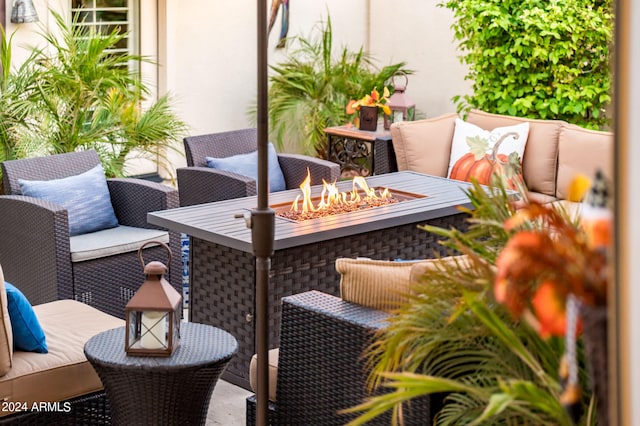 balcony with an outdoor living space with a fire pit and a patio area