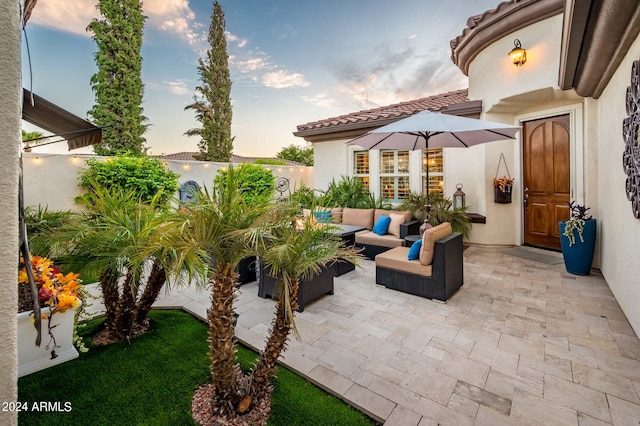 patio terrace at dusk featuring an outdoor hangout area