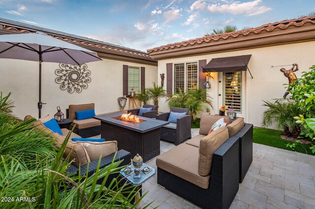 view of patio with an outdoor living space with a fire pit