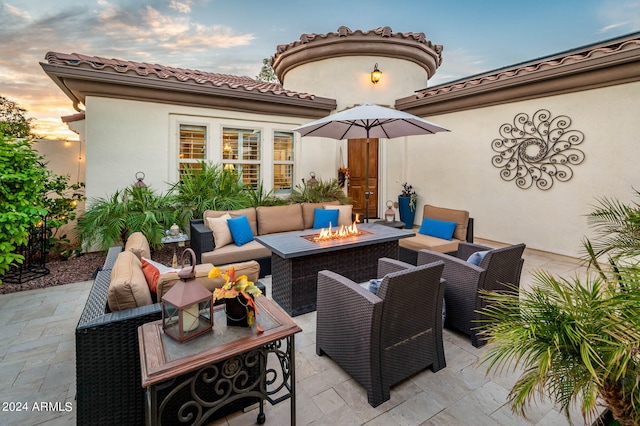 patio terrace at dusk featuring an outdoor living space with a fire pit