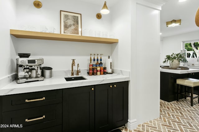 bar featuring sink and light stone countertops