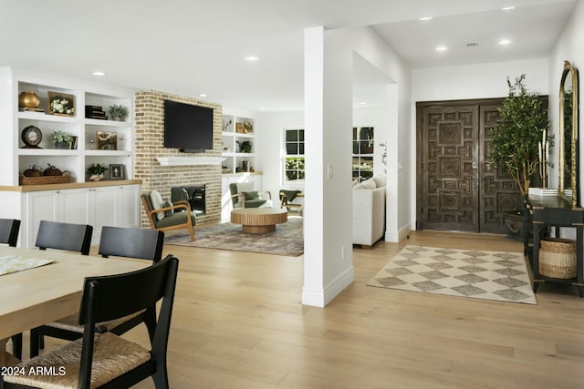 entryway with a fireplace and light hardwood / wood-style flooring