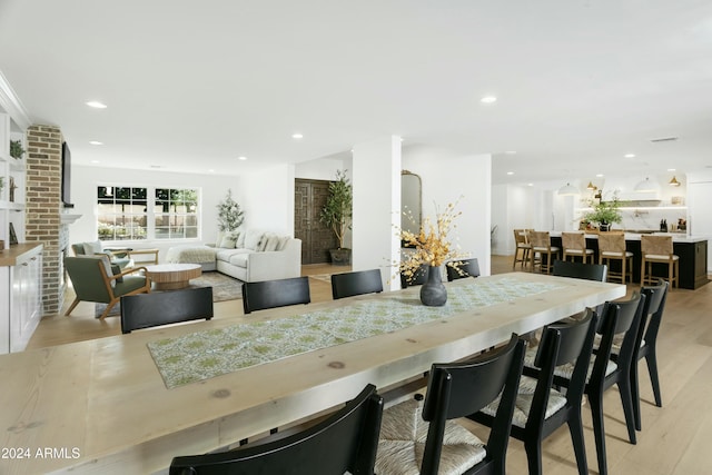 dining room with a fireplace and light hardwood / wood-style floors