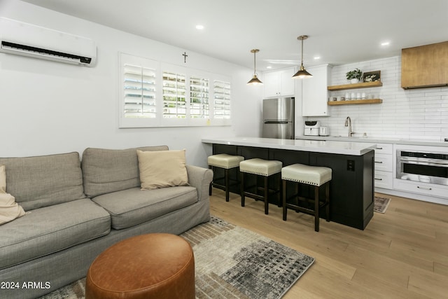 bar featuring stainless steel appliances, white cabinetry, a wall mounted AC, and decorative light fixtures