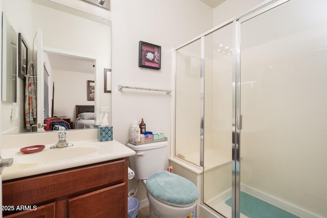 bathroom with a shower with door, vanity, and toilet