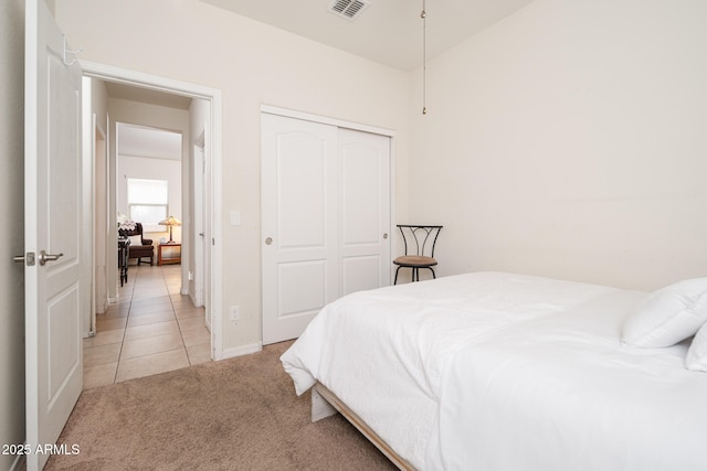 bedroom featuring light carpet and a closet