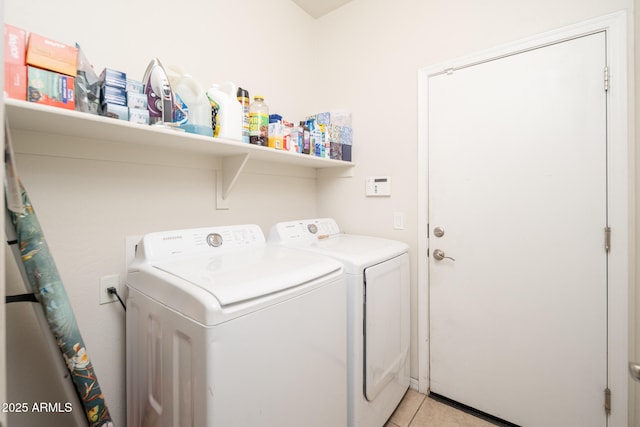 washroom featuring washer and clothes dryer and light tile patterned flooring