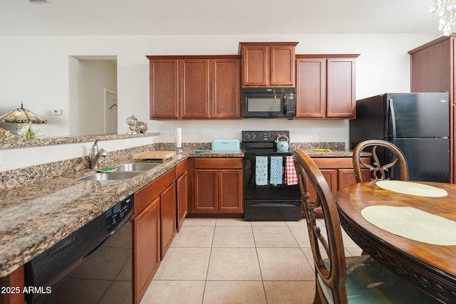 kitchen with light stone countertops, sink, light tile patterned floors, and black appliances