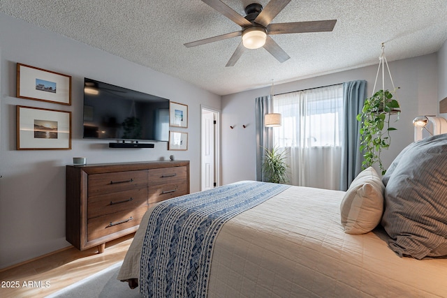 bedroom featuring wood-type flooring, ceiling fan, and a textured ceiling