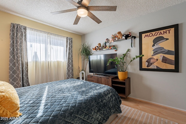 bedroom featuring hardwood / wood-style flooring, ceiling fan, and a textured ceiling