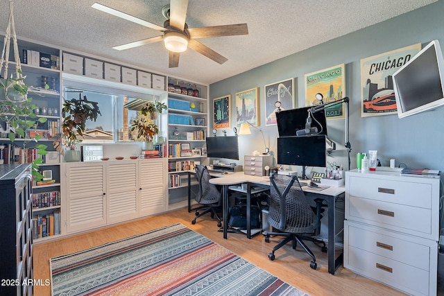 office featuring ceiling fan, light hardwood / wood-style flooring, and a textured ceiling