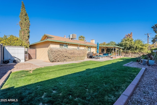 rear view of property featuring a patio, central AC, and a lawn