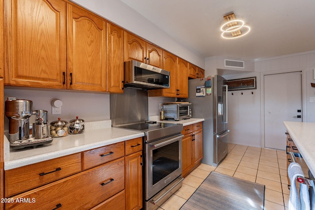 kitchen featuring stainless steel appliances and light tile patterned flooring