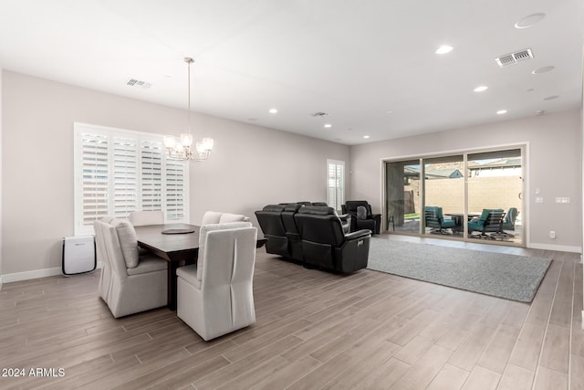 dining space featuring light hardwood / wood-style floors and an inviting chandelier