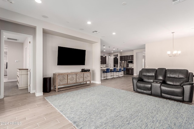 living room with light hardwood / wood-style flooring and an inviting chandelier