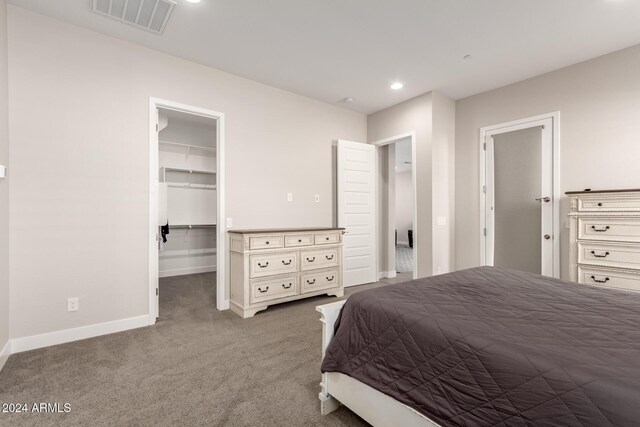 bedroom featuring carpet, a spacious closet, and a closet