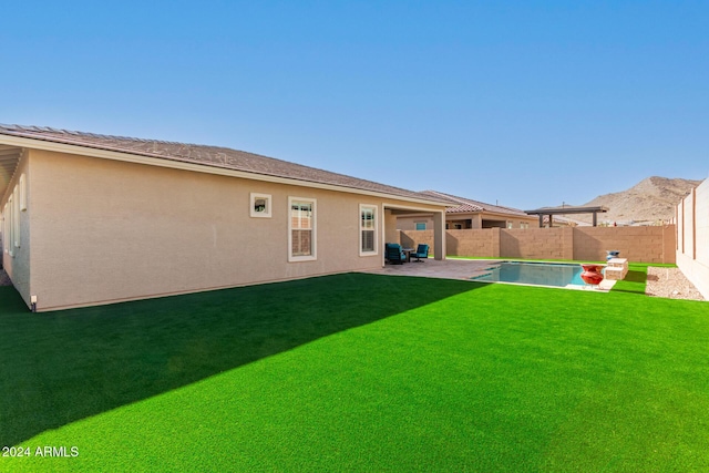 rear view of house with a lawn and a patio