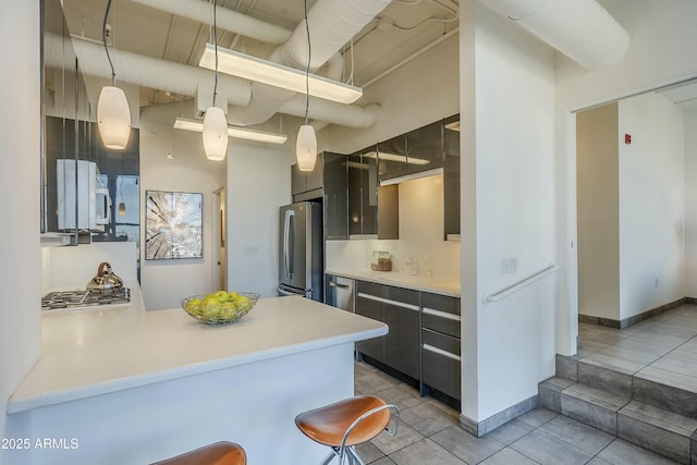 kitchen featuring pendant lighting, kitchen peninsula, a breakfast bar area, and appliances with stainless steel finishes