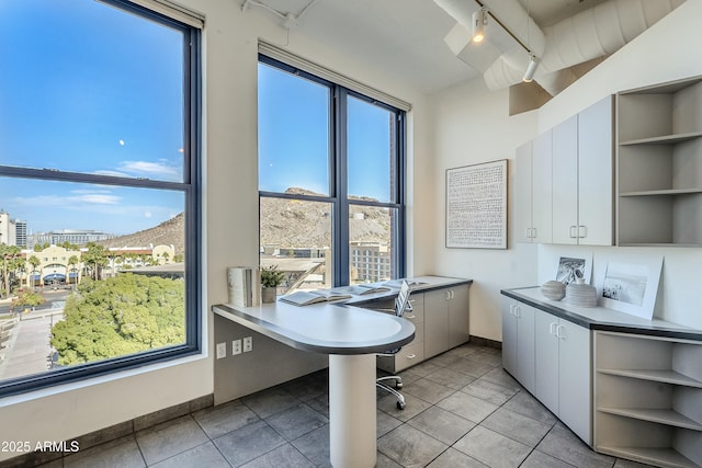 interior space with light tile patterned floors, white cabinetry, and a healthy amount of sunlight