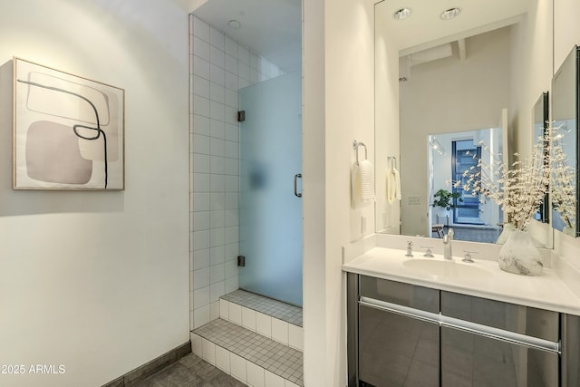 bathroom featuring tiled shower, vanity, and tile patterned flooring