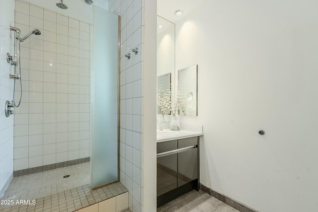 bathroom with a tile shower, tile patterned floors, and vanity