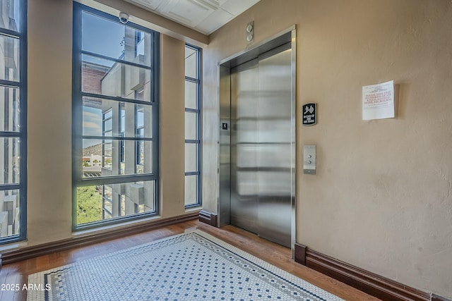 doorway to outside featuring hardwood / wood-style floors and elevator