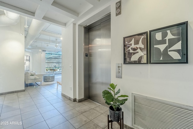 corridor featuring light tile patterned floors and elevator