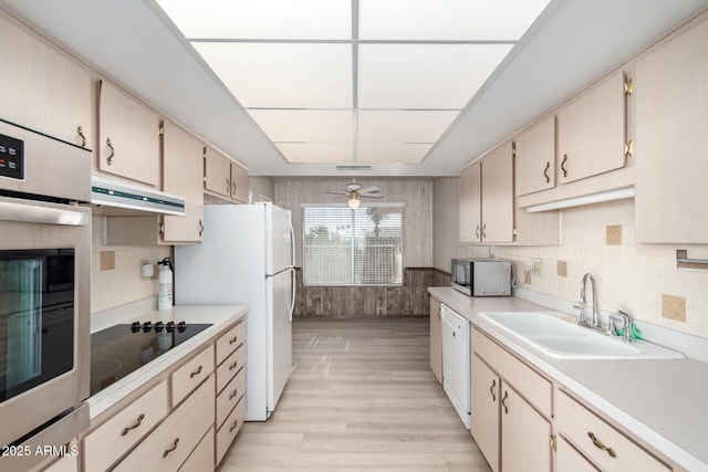 kitchen featuring sink, white appliances, ceiling fan, light hardwood / wood-style floors, and decorative backsplash