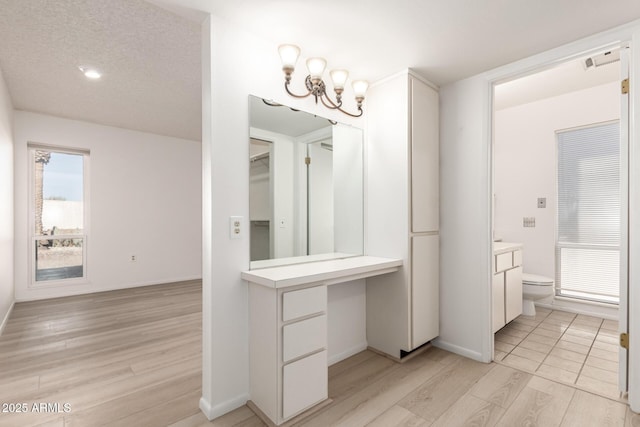 bathroom with an inviting chandelier, vanity, toilet, and hardwood / wood-style floors