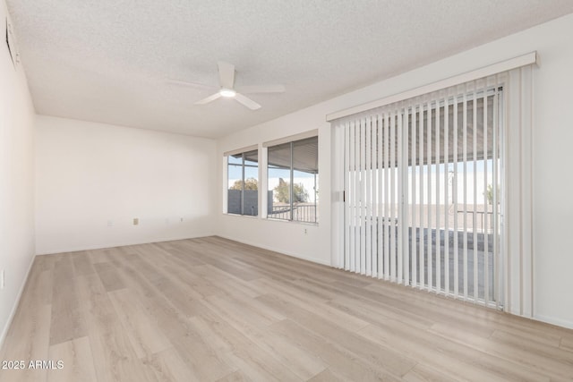 spare room with ceiling fan, a textured ceiling, and light wood-type flooring