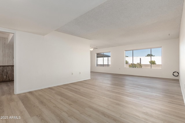 spare room featuring ceiling fan, light hardwood / wood-style flooring, and a textured ceiling