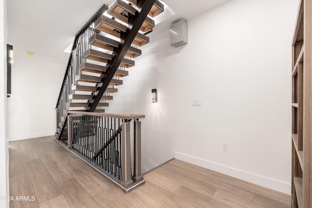 stairway featuring baseboards and wood finished floors