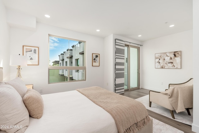 bedroom featuring wood finished floors, access to exterior, and recessed lighting