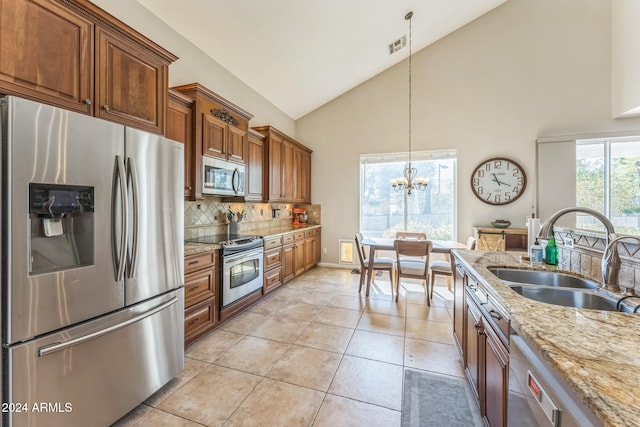 kitchen featuring light tile patterned flooring, appliances with stainless steel finishes, high vaulted ceiling, pendant lighting, and sink