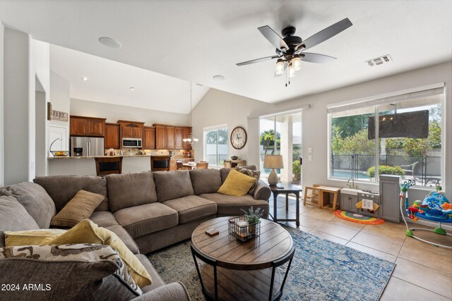 living room with light tile patterned floors, ceiling fan, and vaulted ceiling