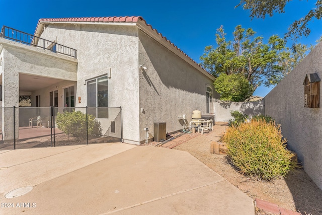 rear view of house featuring a balcony and a patio area