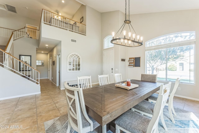 tiled dining space featuring high vaulted ceiling and a chandelier