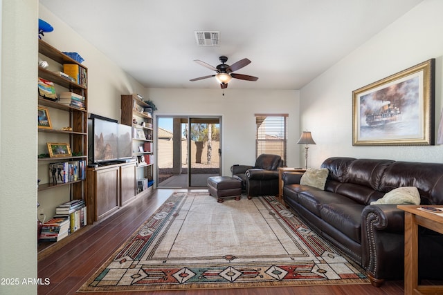 living area featuring dark wood-style floors, visible vents, and a ceiling fan