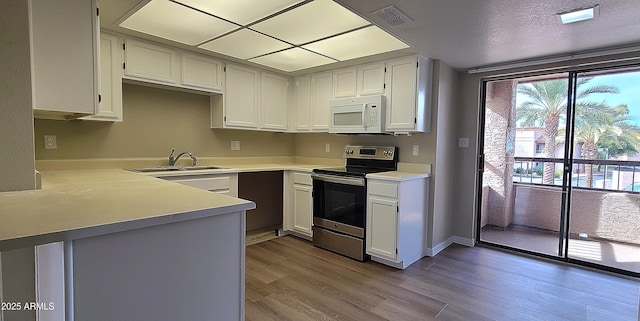 kitchen with sink, light hardwood / wood-style flooring, white cabinetry, electric range, and kitchen peninsula