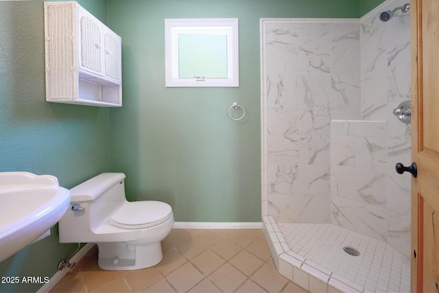 bathroom with tile patterned floors, sink, toilet, and tiled shower