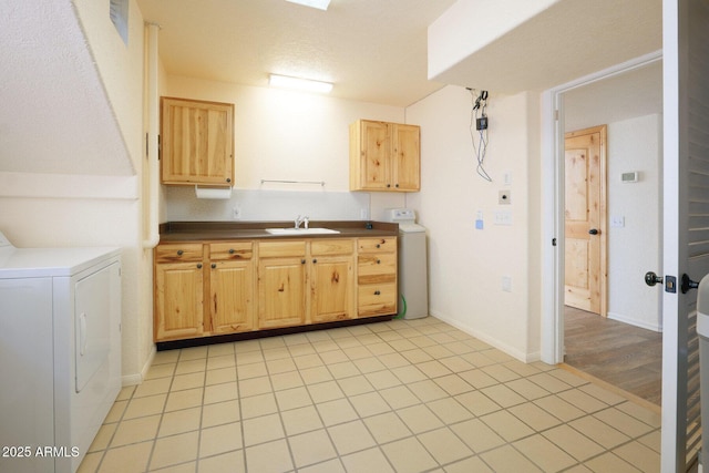 kitchen featuring sink, washer / clothes dryer, and light tile patterned flooring