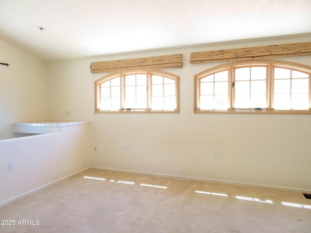 carpeted empty room featuring vaulted ceiling