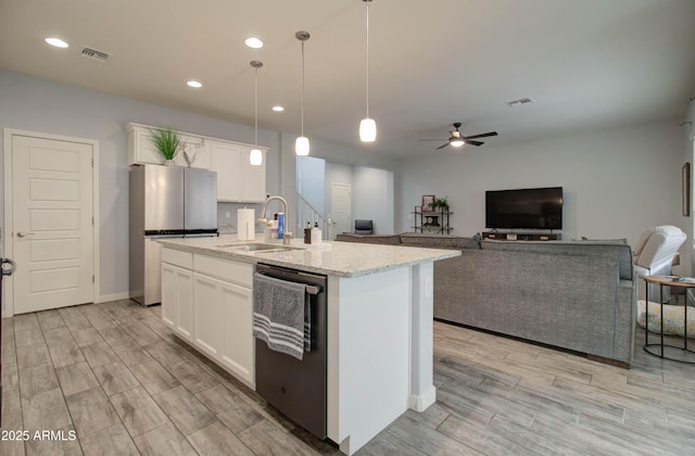 kitchen featuring dishwashing machine, visible vents, freestanding refrigerator, and a sink