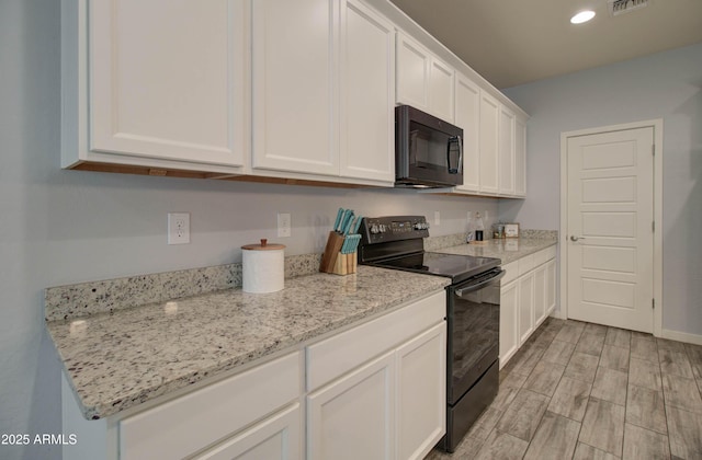 kitchen featuring visible vents, light wood-style floors, white cabinetry, black appliances, and recessed lighting