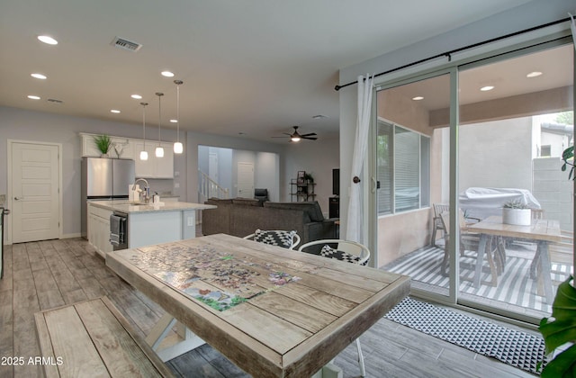 dining room with light wood-style floors, recessed lighting, visible vents, and a ceiling fan