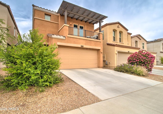 mediterranean / spanish house with a tiled roof, stucco siding, a balcony, a garage, and concrete driveway