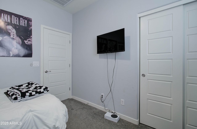 bedroom with dark carpet, a closet, baseboards, and visible vents