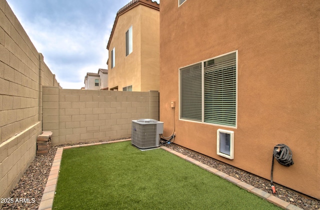 view of yard featuring a fenced backyard and central AC