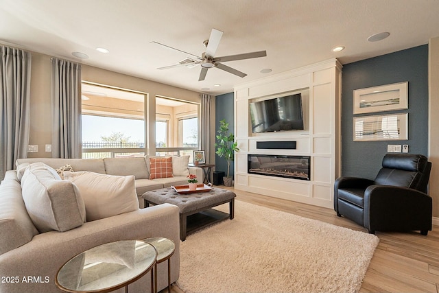 living room featuring light hardwood / wood-style flooring and ceiling fan