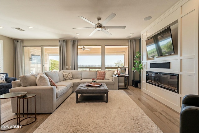 living room featuring ceiling fan and light hardwood / wood-style floors